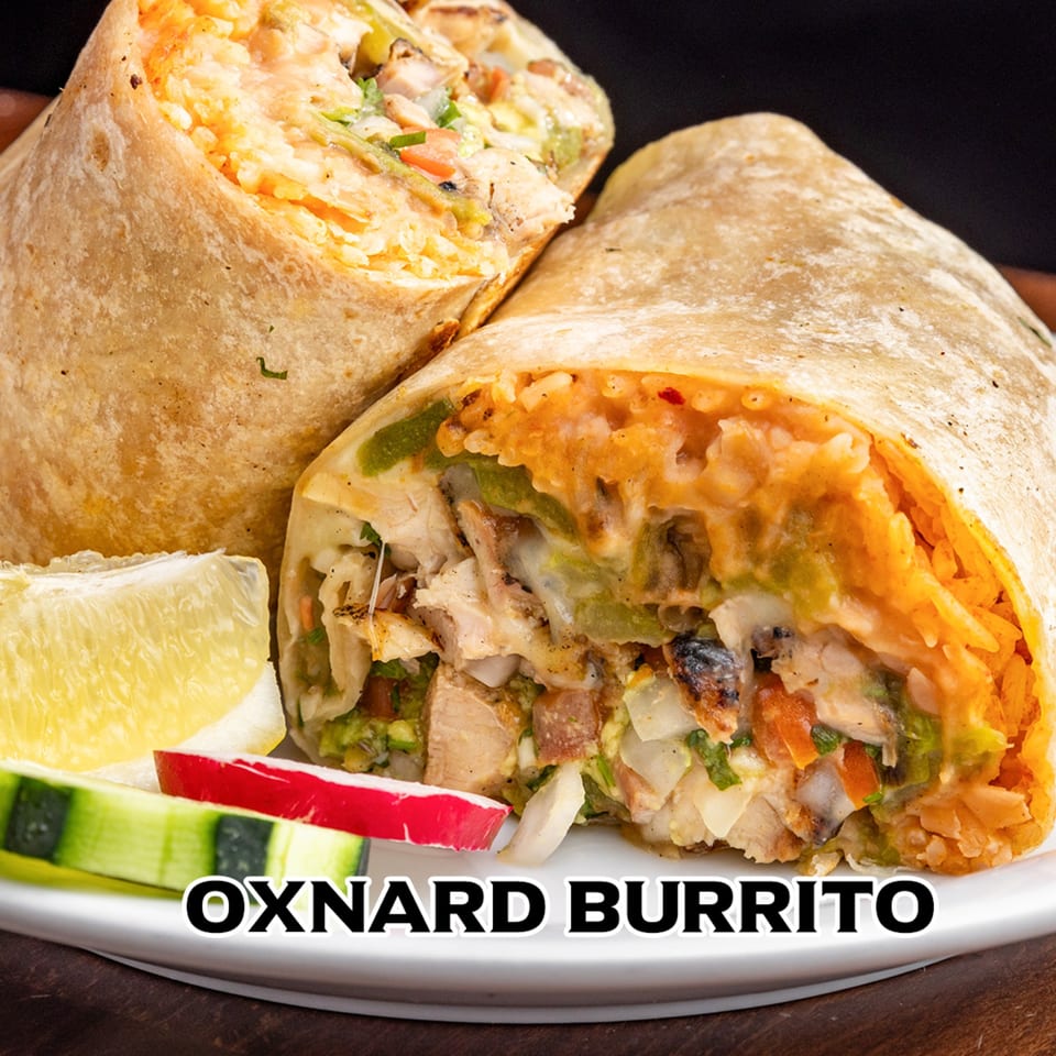 Two House of Tacos Grill burritos, one cut open, revealing chicken, rice, and vegetables, with lime and cucumber.