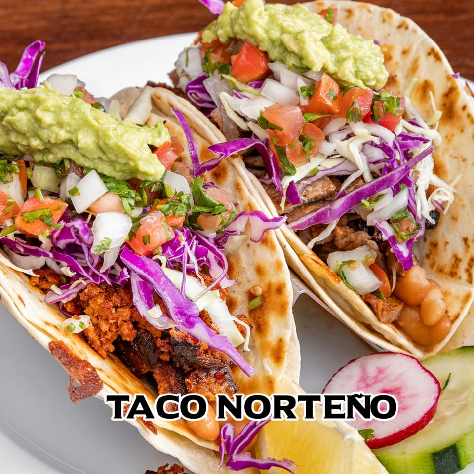 Two House of Tacos Grill tacos with meat, purple cabbage, pico de gallo, and guacamole.