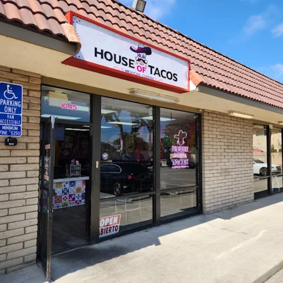 Exterior of House of Tacos Grill, a Mexican restaurant with a prominent sign and accessible parking.