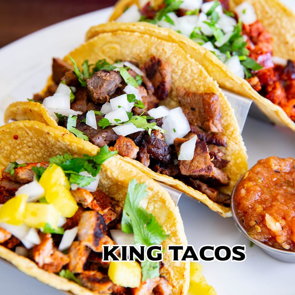 Three House of Tacos Grill tacos with various fillings, onions, cilantro, and a side of salsa.