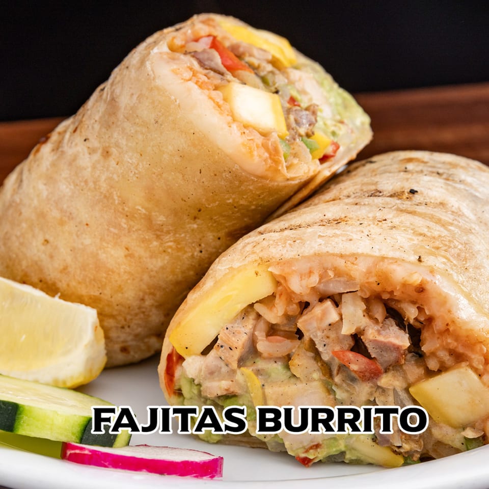 Two House of Tacos Grill fajitas burritos, sliced, with a side of lemon, cucumber, and radish.