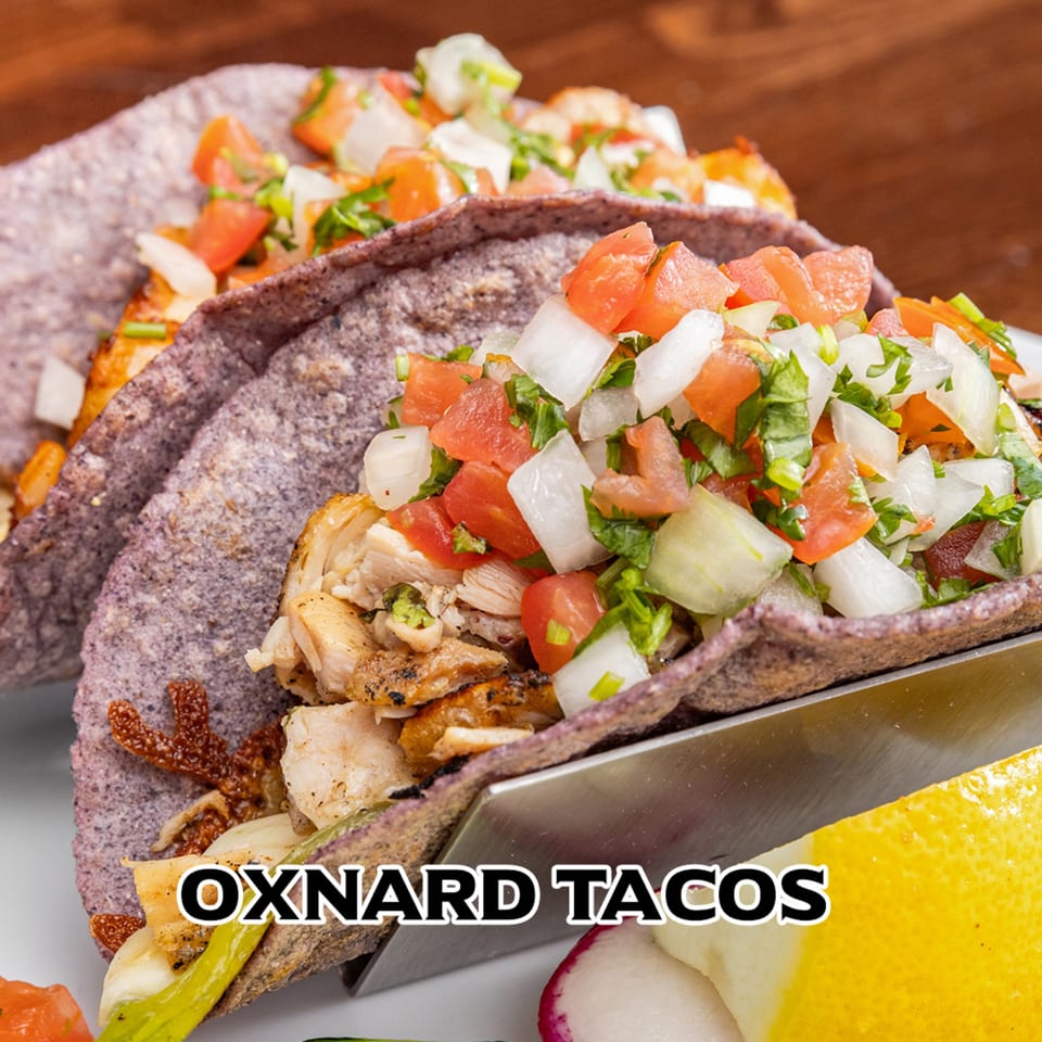 Two Oxnard Tacos from House of Tacos Grill, filled with meat, pico de gallo, and onions.